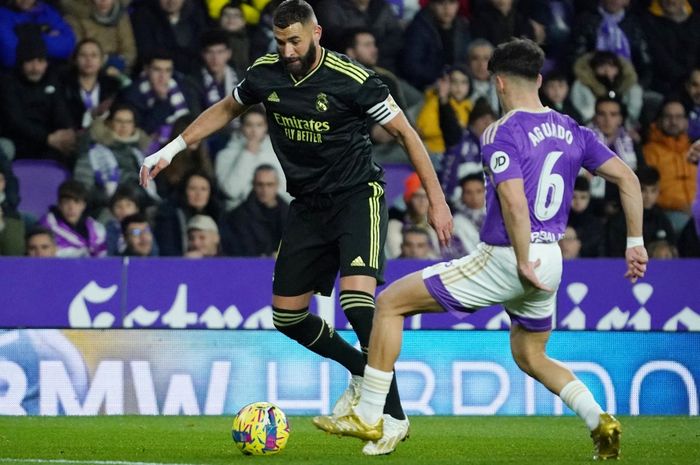 Striker Real Madrid, Karim Benzema, berduel dengan gelandang Real Valladolid, Alvaro Aguado, dalam laga Liga Spanyol di Stadion Jose Zorilla, Jumat (30/12/2022).