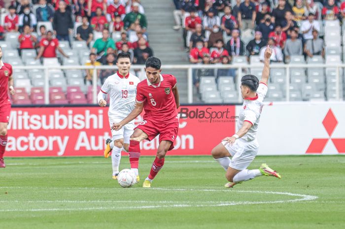 Gelandang timnas Indonesia, Marselino Ferdinan (tengah), sedang menguasai bola dan dibayangi salah satu pemain timnas Vietnam bernama Nguyen Quang Hai (kiri) dalam laga leg pertama semifinal Piala AFF 2022 di Stadion Gelora Bung Karno, Senayan, Jakarta, 6 Januari 2023.