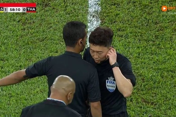 Wasit Kim Dae-yong berdiskusi dengan wasit cadangan asal Indonesia, Thoriq Alkatiri.