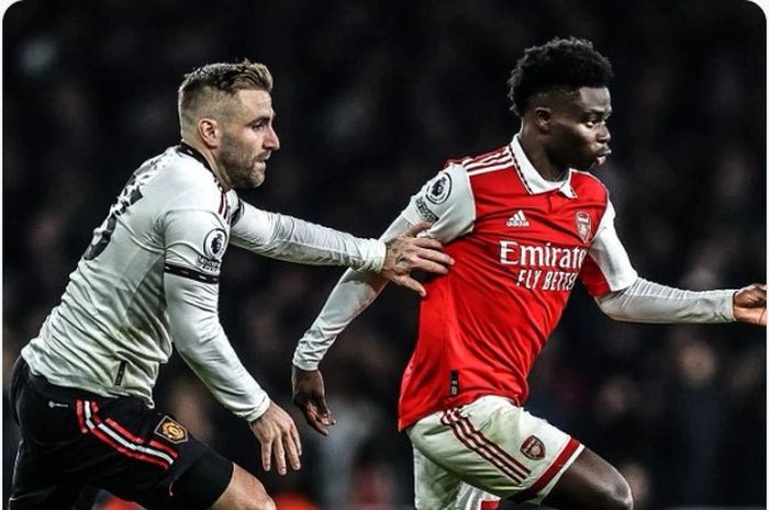 Pemain Man United, Luke Shaw (kiri), berduel dengan pemain Arsenal , Bukayo Saka (kanan), dalam laga pekan ke-21 Liga Inggris 2022-2023.