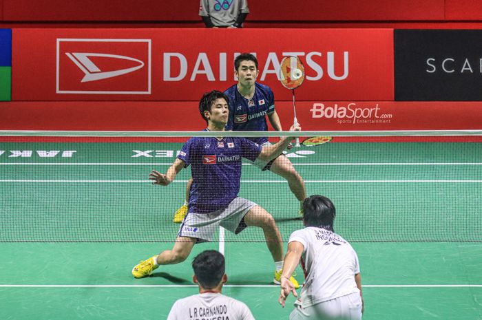 Ganda putra Jepang, Yugo Kobayashi,  memukul kok saat tampil bersama Takuro Hoki pada semifinal Indonesia Masters 2023 di Istora Senayan, Jakarta, 28 Januari 2023.