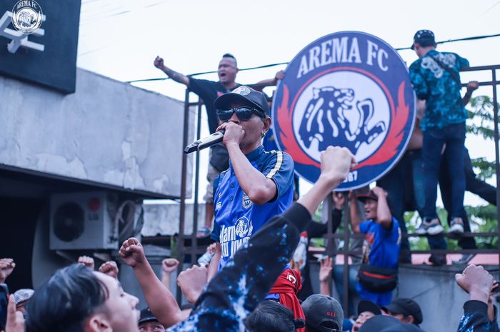 Suporter Aremania memasang kembali logo Arema FC yang rusak dibakar. 