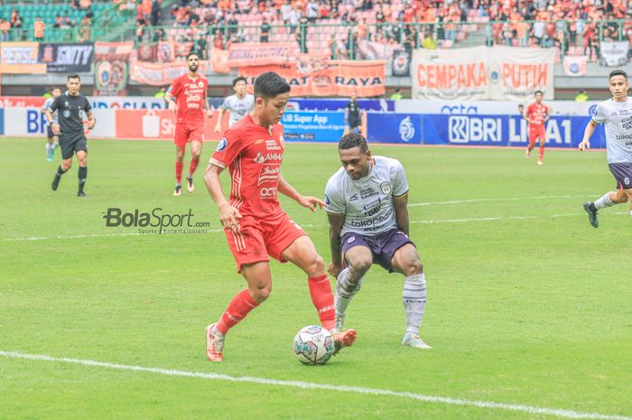 Bek sayap kanan Persija Jakarta, Ilham Rio Fahmi (kiri), sedang menguasai bola dan dibayangi pemain RANS Nusantara FC bernama David Laly (kanan) dalam laga pekan ke-22 Liga 1 2022 di Stadion Patriot Candrabhaga, Bekasi, Jawa Barat, Jumat (3/2/2023).