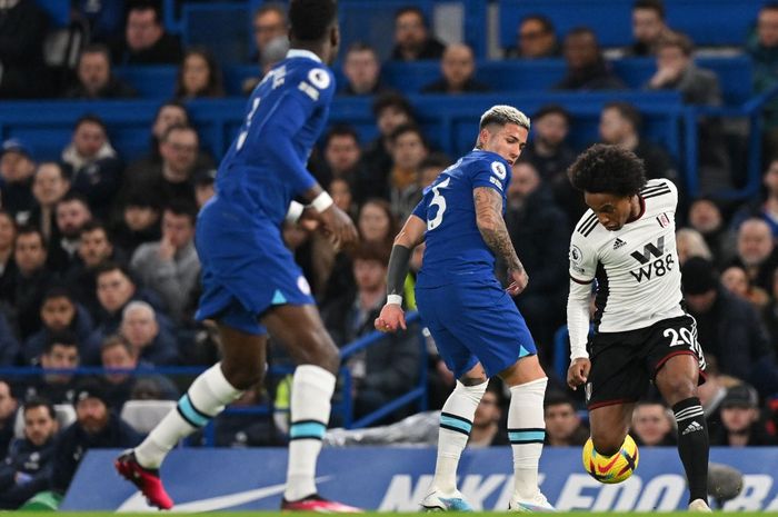 Gelandang Chelsea, Enzo Fernandez (Tengah), memperebutkan bola melawan gelandang Fulham, Willian,  selama pertandingan Liga Inggris 2022-2023 antara Chelsea dan Fulham di Stamford Bridge, Sabtu (4/2/2023) dini hari WIB. 