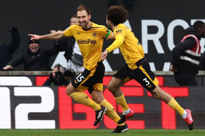 Bek Wolverhampton Wanderers, Craig Dawson (15) merayakan dengan rekannya, Rayan Ait-Nouri, (kanan) setelah mencetak gol kedua timnya selama pertandingan Liga Inggris antara Wolverhampton Wanderers dan Liverpool di stadion Molineux, Sabtu (4/2/2022).