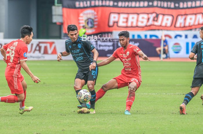 Striker Arema FC, Dedik Setiawan (kiri), sedang menguasai bola dan dijaga gelandang Persija Jakarta bernama Resky Fandi (kanan) dalam laga pekan ke-24 Liga 1 2022 di Stadion Patriot Candrabhaga, Bekasi, Jawa Barat, 12 Februari 2023.