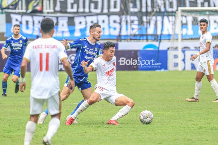 Pemain PSM Makassar, Akbar Tanjung (kanan), sedang mengusai bola dan dibayangi gelandang Persib Bandung bernama Marc Klok (kiri) dalam laga pekan ke-24 Liga 1 2022 di Stadion Pakansari, Bogor, Jawa Barat, 14 Februari 2023.