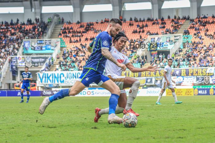 Gelandang Persib Bandung, Marc Klok (kiri), sedang menguasai bola dan dikawal bek PSM Makassar bernama Erwin Gutawa (kanan) dalam laga pekan ke-24 Liga 1 2022 di Stadion Pakansari, Bogor, Jawa Barat, Selasa (14/2/2023).