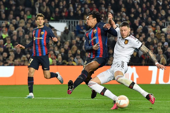 Penyerang Manchester United, Wout Weghorst, saat berduel dengan bek Barcelona, Jules Kounde, pada partai leg pertama play-off babak 16 besar Liga Europa 2022-2023, Kamis (16/2/2023).