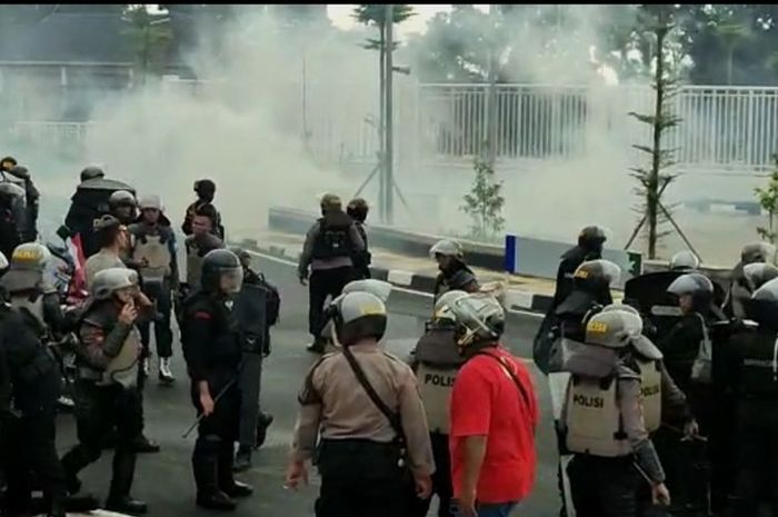 Polisi tembakan gas air mata untuk meredam suporter yang ingin masuk Stadion Jatidiri Semarang. 