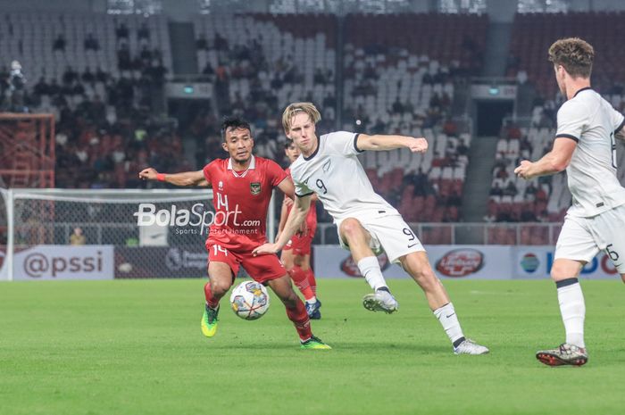 Striker timnas U-20 Selandia Baru, Kian Donkers (kanan), sedang mengoper bola dan dibayangi pemain timnas U-20 Indonesia bernama Robi Darwis (kiri) dalam laga turnamen Mini Internasional di Stadion Gelora Bung Karno, Senayan, Jakarta, Minggu (19/2/2023) malam.