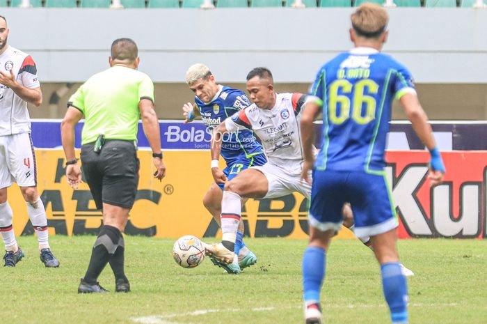 Striker asing Persib Bandung, Ciro Alves (kiri), sedang berebut bola dengan bek Arema FC bernama Joko Susilo (kanan) dalam laga pekan ke-26 Liga 1 2022 di Stadion Pakansari, Bogor, Jawa Barat, Kamis (23/2/2023).