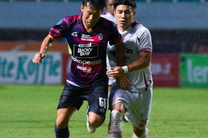 Pemain RANS Nusantatra FC, Mitsuru Maruoka, mendapat kawalan ketat dari pemain Persis Solo Ryo Matsumura pada laga pekan ke-29 Liga 1 2022/2023. 