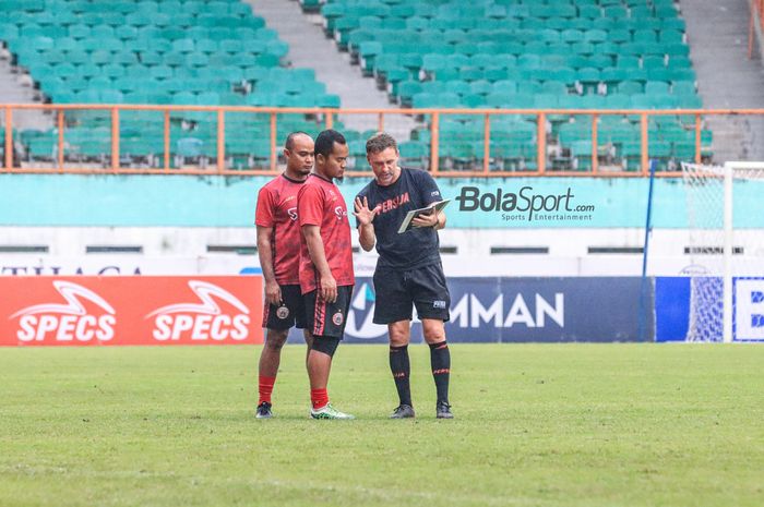 Pelatih Persija Jakarta, Thomas Doll (kanan), sedang berkomunikasi dengan beberapa asistennya di Stadion Wibawa Mukti, Cikarang, Jawa Barat, Rabu (15/3/2023),