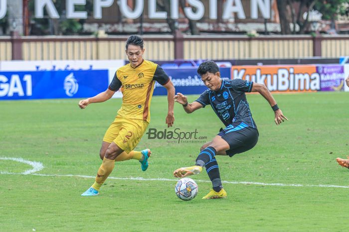 Striker Arema FC, Dedik Setiawan (kanan), sedang menguasai bola dan dibayangi bek Persikabo 1973 bernama Andy Setyo (kiri) dalam laga pekan ke-31 Liga 1 2022 di Stadion PTIK, Blok M, Jakarta, Minggu (19/3/2023).