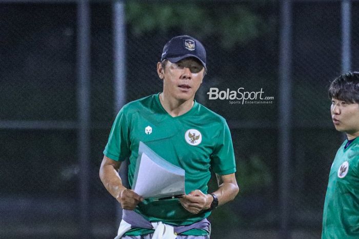 Pelatih timnas Indonesia, Shin Tae-yong (kiri), sedang memantau para pemainnya berlatih di Lapangan Latih JIS (Jakarta International Stadium), Jakarta  Utara, Kamis (23/3/2023).