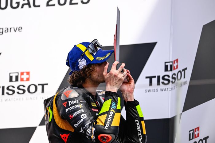 Pembalap Mooney VR46, Marco Bezzecchi mencium trofi usai finis ketiga pada balapan MotoGP Portugal 2023