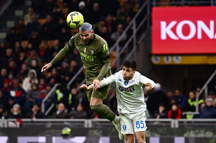 Bek AC Milan, Theo Hernandez (Kiri), menyundul bola di sebelah bek Empoli Italia Fabiano Parisi selama pertandingan sepak bola Liga Italia 2022-2023 antara AC Milan dan Empoli FC di Stadion San Siro di Milan pada 7 April 2023. 