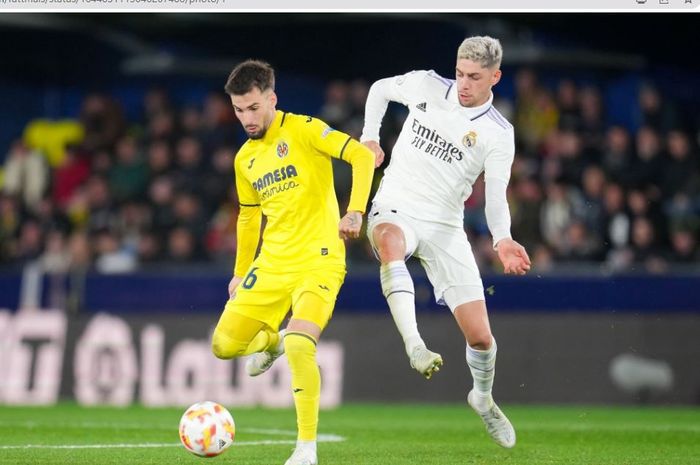 Gelandang Real Madrid, Fede Valverde (putih), berebut bola dengan gelandang Villarreal, Alex Baena (kuning).