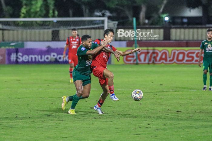 Gelandang Arema FC, Renshi Yamaguchi (kanan), sedang menguasai bola dan dibayangi striker Persebaya Surabaya bernama Paulo Victor (kiri) dalam laga tunda pekan ke-28 Liga 1 2022 di Stadion PTIK, Blok M, Jakarta, Selasa (11/4/2023) malam.