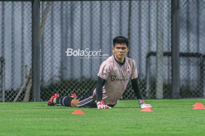 Kiper Persija Jakarta, Cahya Supriadi, sedang melakukan pemanasan jelang berlatih di Lapangan Latih JIS (Jakarta International Stadium), Jakarta, Utara, Rabu (12/4/2023) malam.