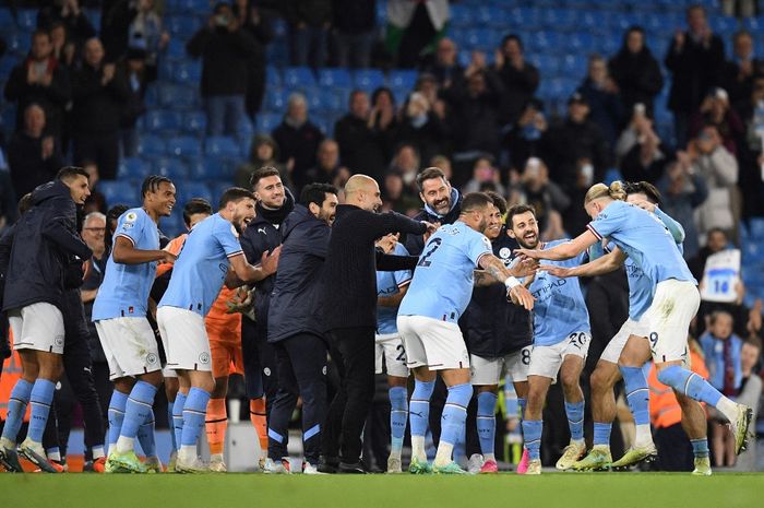 Manchester City's Norwegian striker Erling Haaland (R) celebrates the title of 