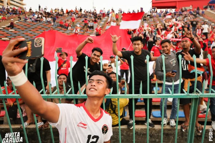 Bek Timnas U-22 Indonesia Pratama Arhan berswafoto dengan suporter seusai menang 3-0 atas Timor Leste dalam SEA Games 2023 di Kamboja.