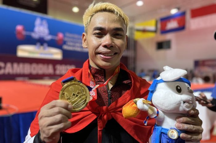 Lifter Indonesia Eko Yuli Irawan berpose usai menenangkan medali emas di cabang angkat besi 61 kg putra di SEA Games 2023 Kamboja, Sabtu (13/5/2023). 