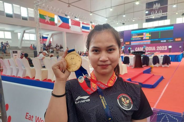 ifter Juliana Klarisa memamerkan medali emas SEA Games XXXII/2023 Kamboja usai menjadi yang terbaik di kelas 55kg putri di National Olympic Stadium, Minggu (14/5/2023).