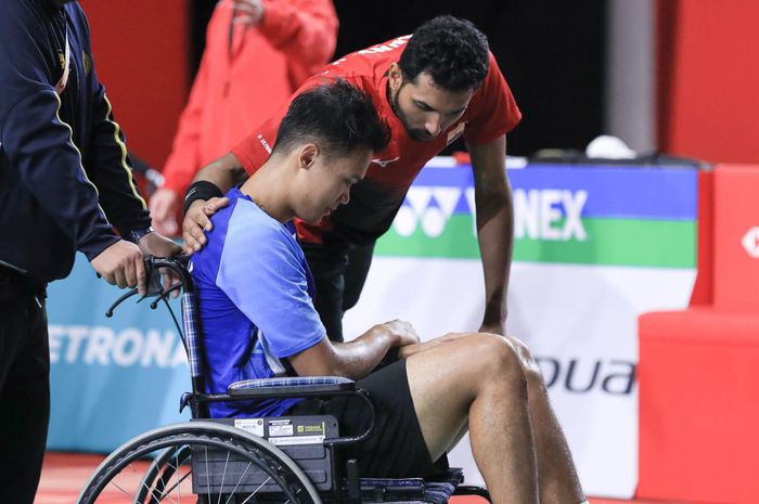 Pebulu tangkis tunggal putra Indonesia, Christian Adinata, ditemani H.S Prannoy (India) setelah laga terhenti karena Christian cedera pada semifinal Malaysia Masters 2023 di Axiata Arena, Kuala Lumpur, Sabtu (27/5/2023).