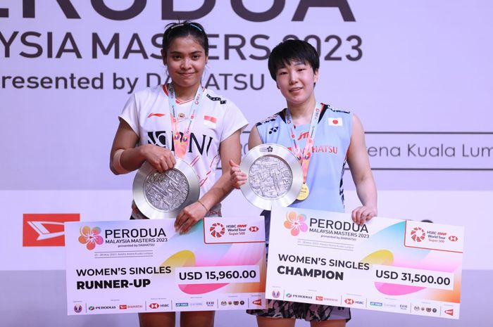 Pebulu tangkis tunggal putri Indonesia, Gregoria Mariska Tunjung (kiri) dan Akane Yamaguchi (Jepang) di podium Malaysia Masters 2023 di Axiata Arena, Kuala Lumpur, Minggu (28/5/2023).