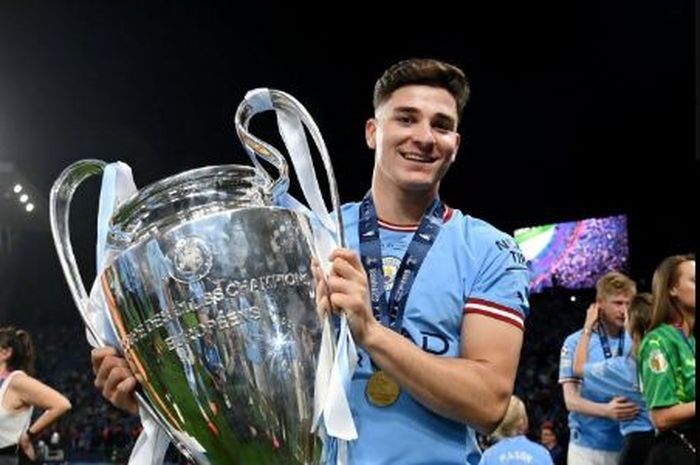 Penyerang Manchester City, Julian Alvarez, mengangkat trofi Liga Champions.