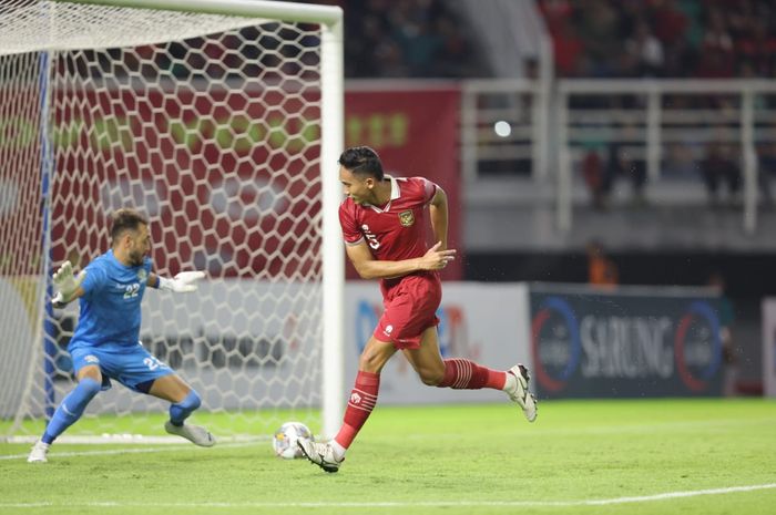 Bek timnas Indonesia Rizky Ridho berhadapan dengan kiper Palestina.