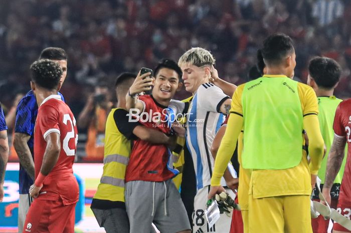 Seorang oknum suporter masuk ke dalam lapangan seusai laga timnas Indonesia versus timnas Argentina dan berfoto selfie dengan Alejandro Garnacho di Stadion Utama Gelora Bung Karno, Senayan, Jakarta, 19 Juni 2023.