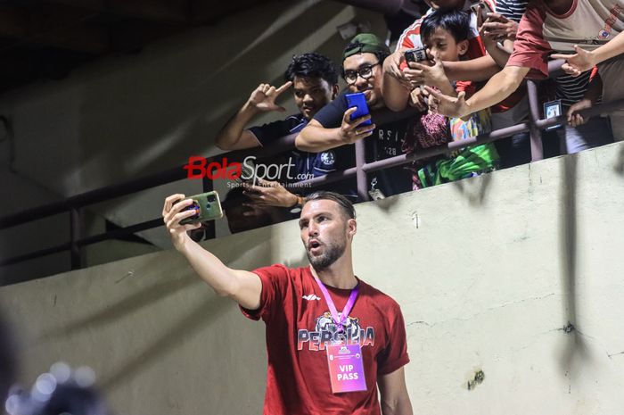 Striker asing pemain Persija Jakarta, Marko Simic (depan), sedang berfoto selfie dengan sejumlah The Jakmania (suporter Persija) di Stadion PTIK, Blok M, Jakarta, Rabu (21/6/2023) malam.