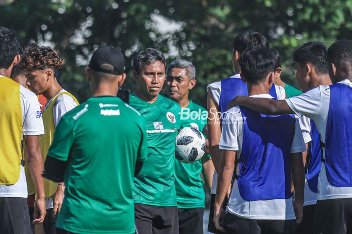 Pelatih timnas U-17 Indonesia, Bima Sakti, sedang memberikan intruksi kepada para pemainnya saat berlatih di Lapangan A, Senayan, Jakarta, Kamis (20/7/2023) pagi.