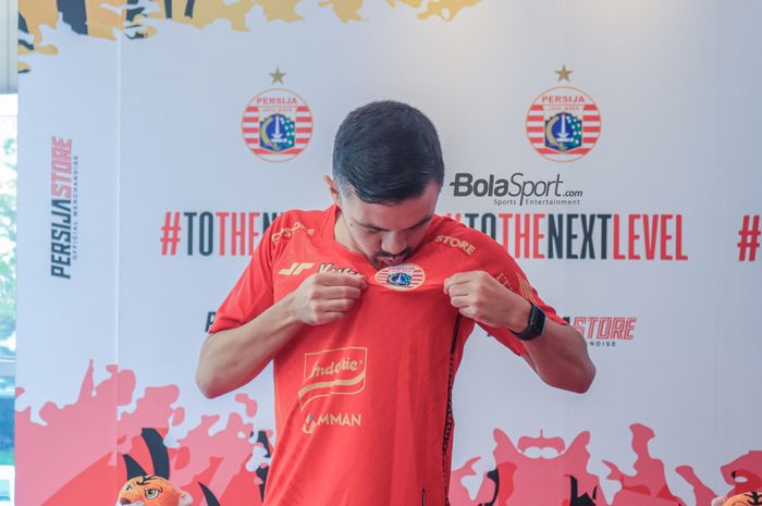 Pemain asing baru Persija Jakarta, Oliver Bias, sedang pose foto cium logo klub dalam peresmiannya di Persija Store, Kuningan, Jakarta, Kamis (27/7/2023).