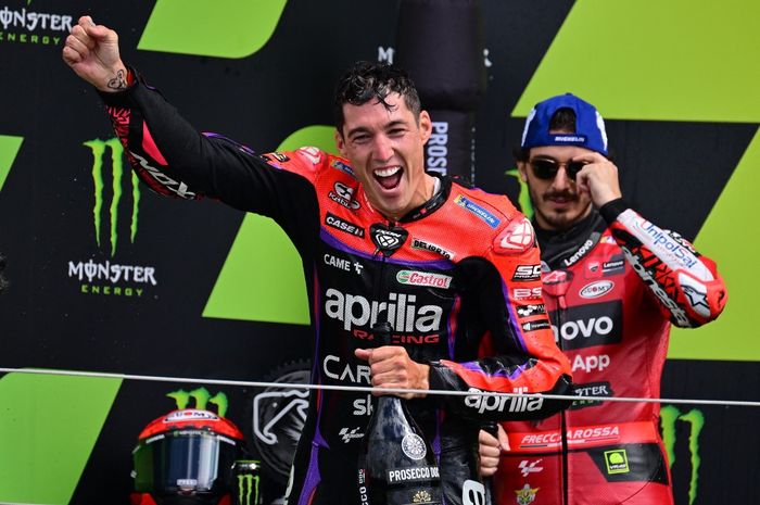 Pembalap Aprilia Racing, Aleix Espargaro (kiri), merayakan kemenangannya di podium setelah balapan MotoGP Inggris di Sirkuit Silverstone, Northamptonshire, Inggris, 6 Agustus 2023. Juga tampak dalam gambar adalah Francesco Bagnaia dari tim Ducati Lenovo yang menjadi runner-up.