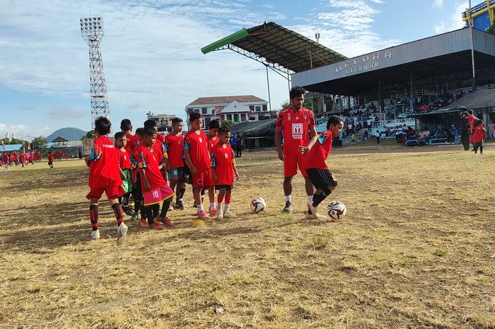 Pemain Malut United FC, Ilham Udin Almaiyn, membimbing anak-anak dalam acara coaching clinic di Stadion Gelora Kie Raha, Ternate, Minggu (13/8/2023).