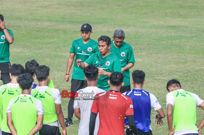 Pelatih timnas U-17 Indonesia, Bima Sakti (tengah), sedang memberikan intruksi kepada para pemainnya saat berlatih di Lapangan A, Senayan, Jakarta, Sabtu (26/8/2023). 