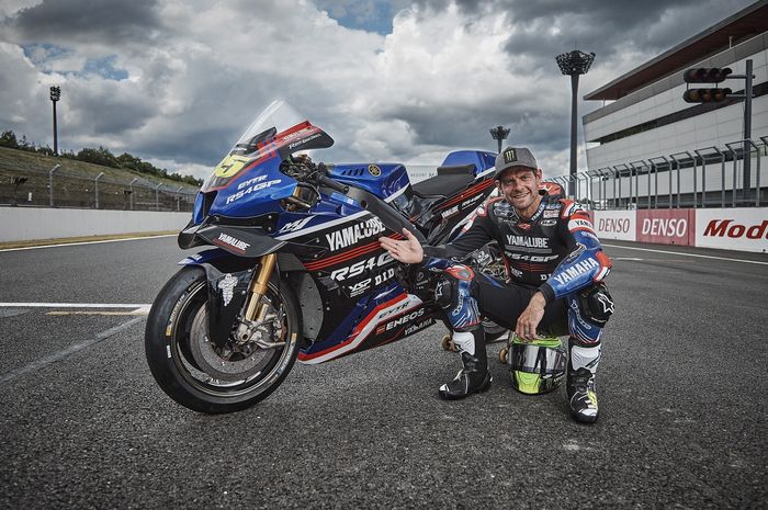 Pembalap penguji Yamaha, Cal Crutchlow, berpose bersama motor tim Yamalube RS4GP yang akan digunakannya saat tampil sebagai wildcard pada seri MotoGP Jepang di Sirkuit Motegi pada 29 September-1 Oktober 2023.