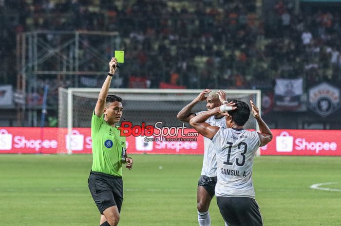 Wasit yang memimpin laga pekan ke-16 Liga 1 2023 antara Persija versus RANS Nusantara FC yang bernama Naufal Adya Fairuski (kiri) memberikan kartu kuning kepada Samsul Arifin (kanan) di Stadion Patriot Candrabhaga, Bekasi, Jawa Barat, Minggu (22/10/2023).