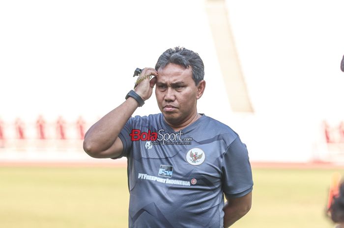 Pelatih timnas U-17 Indonesia, Bima Sakti, sempat memegangi kepalanya saat memantau para pemainnya berlatih di Stadion Utama Gelora Bung Karno, Senayan, Jakarta, Senin (30/10/2023).