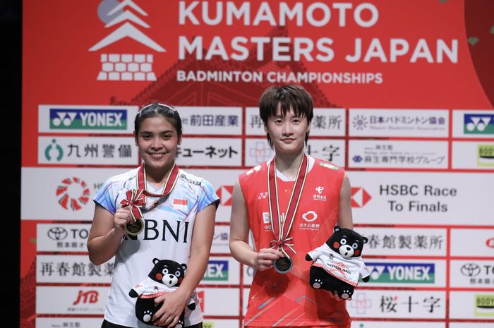 Gregoria Mariska Tunjung berpose di podium juara usai mengalahkan tunggal putri nomor satu China sekaligus peraih emas Olimpiade Tokyo 2020, Chen Yu Fei (kanan) pada Kumamoto Masters 2023 di Kumamoto Prefectural Gymnasium, Kumamoto, Jepang, Minggu (19/11/2023)