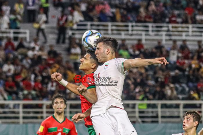 Abolfazl Zamani (kanan) sedang berduel udara merebut bola dengan Saifdine Chlaghmo (kiri) dalam laga babak 16 besar Piala Dunia U-17 2023 antara timnas U-17 Maroko versus timnas U-17 Iran di Stadion Gelora Bung Tomo, Surabaya, Jawa Timur, Selasa (21/11/2023) malam.