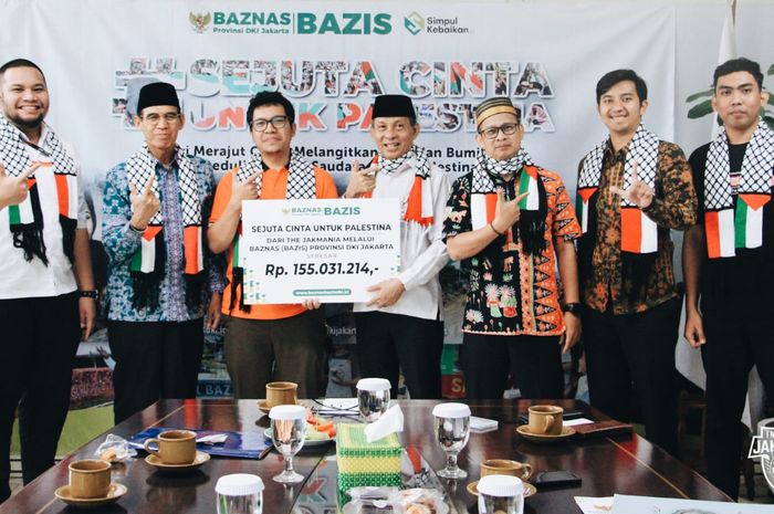 Suporter Persija Jakarta, The Jakmania, menyerahkan sumbangan uang untuk korban di Palestina