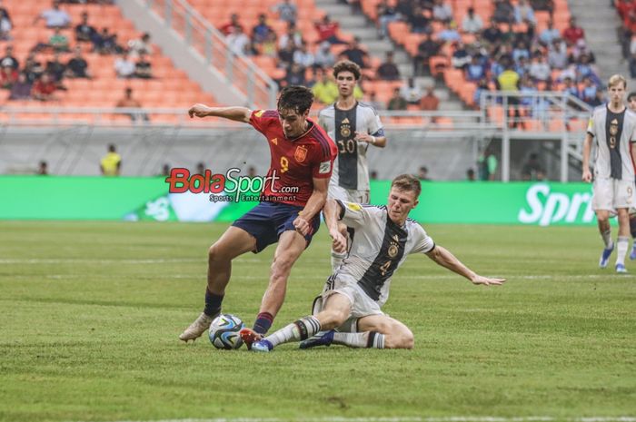 Marc Guiu (kiri) sedang mengusai bola dan berusaha direbut Fin Jeltsch (kanan) dalam laga babak delapan besar Piala Dunia U-17 2023 antara timnas U-17 Spanyol versus timnas U-17 Jerman di Jakarta International Stadium (JIS), Jakarta Utara, Jumat (24/11/2023).