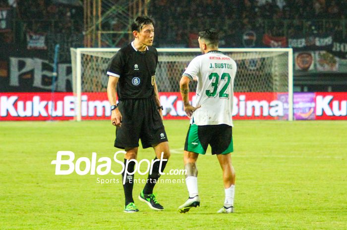 Wasit Asal Jepang Futoshi Nakamura memberi teguran kepada pemain PSS Sleman Jonathan Ezequiel Bustos di pertandingan Persija Jakarta vs PSS Sleman di Stadion Patriot Chandrabhaga, Sabtu (16/12/2023)