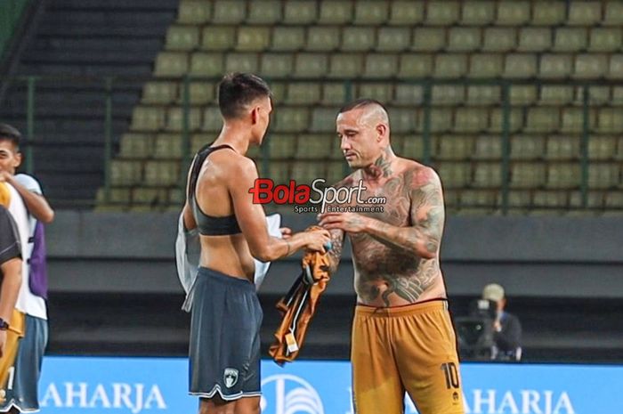 Christian Rontini (kiri) sedang bertukar jersey dengan Radja Nainggolan (kanan) seusai laga pekan ke-23 Liga 1 2023 antara Bhayangkara FC versus Persita Tangerang di Stadion Patriot Candrabhaga, Bekasi, Jawa Barat, Minggu (17/12/2023).