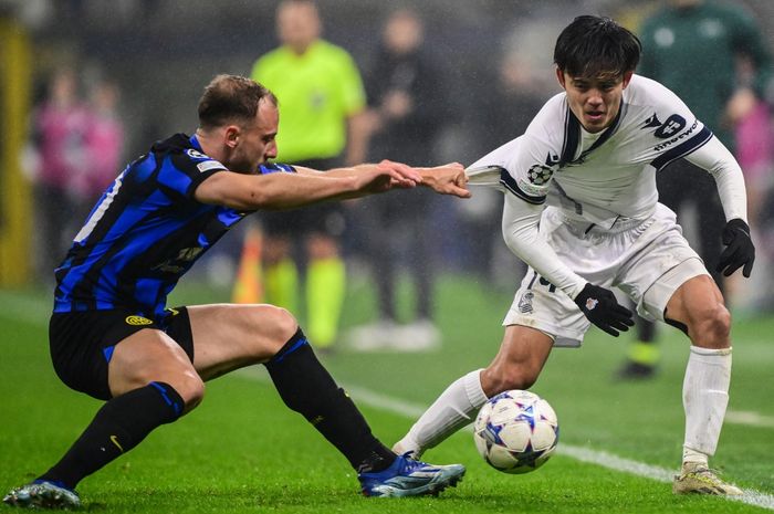 Takefusa Kubo (kanan) ditarik Carlos Augusto saat berlaga dalam partai Inter Milan vs Real Sociedad di Liga Champions. Kubo diincar Man United untuk menggantikan peran Antony, yang kerap dianggap investasi bodong di Setan Merah.